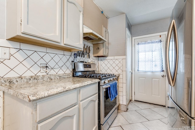 kitchen with light tile patterned floors, stainless steel appliances, premium range hood, and white cabinets