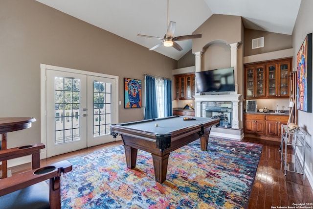 playroom featuring a fireplace with raised hearth, high vaulted ceiling, dark wood-type flooring, visible vents, and french doors