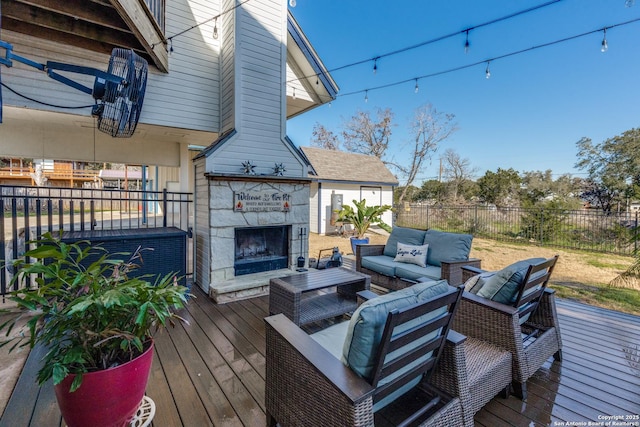 wooden deck with an outdoor living space with a fireplace and fence