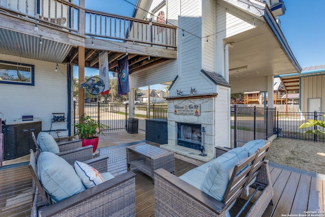 wooden deck with fence and an outdoor living space with a fireplace