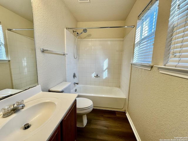 full bath with a textured wall, a textured ceiling, toilet, and wood finished floors