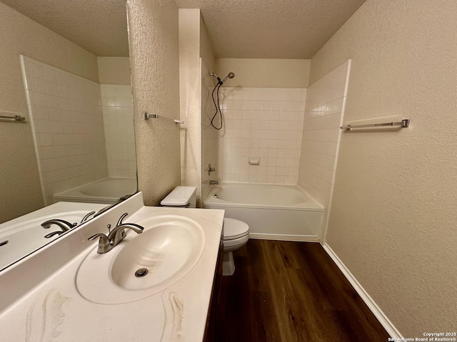 bathroom with bathtub / shower combination, a textured wall, toilet, a textured ceiling, and wood finished floors