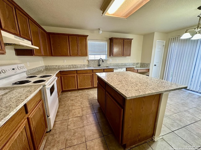 kitchen with a center island, a sink, a textured ceiling, white appliances, and under cabinet range hood