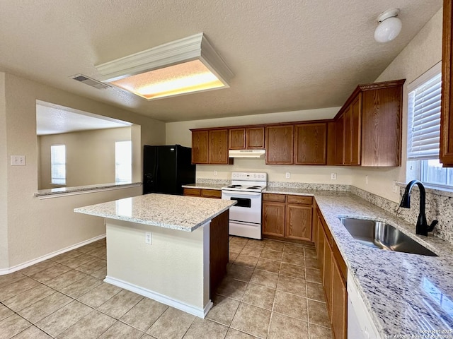 kitchen with visible vents, a healthy amount of sunlight, a sink, white appliances, and under cabinet range hood