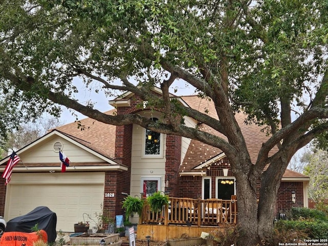 view of front of home with an attached garage, roof with shingles, and brick siding