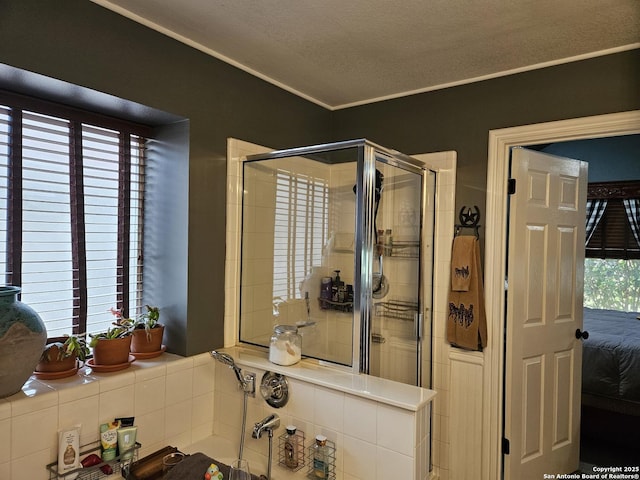 bathroom featuring a textured ceiling, ornamental molding, and a shower stall