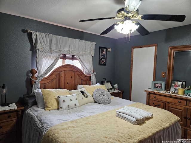 bedroom featuring a textured wall and a ceiling fan