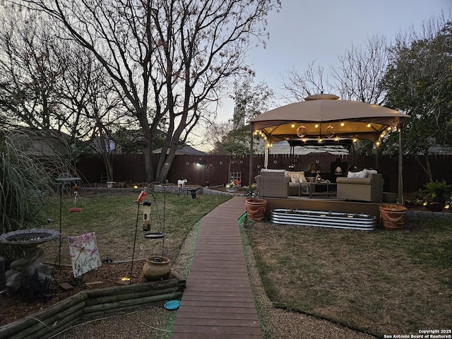 view of yard with a fenced backyard, an outdoor living space, and a gazebo