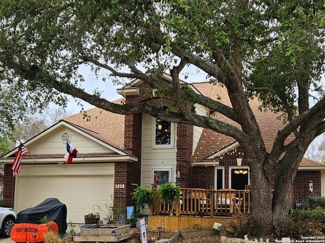 view of front facade featuring an attached garage, a shingled roof, and brick siding