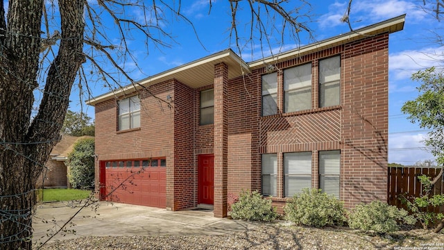 view of front of property featuring a garage, concrete driveway, brick siding, and fence