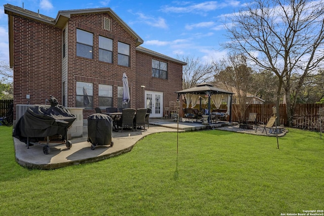 back of property with a patio, a gazebo, fence, french doors, and brick siding