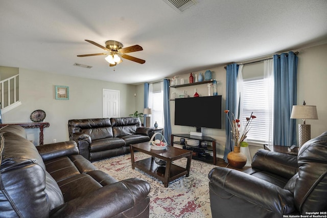 living area featuring ceiling fan, a wealth of natural light, and visible vents