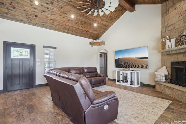 living room with arched walkways, wood ceiling, beamed ceiling, a fireplace, and high vaulted ceiling