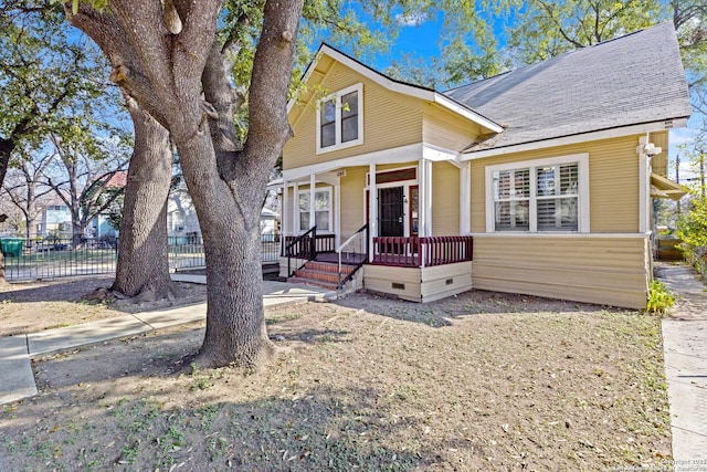 view of front of property with covered porch, roof with shingles, crawl space, and fence