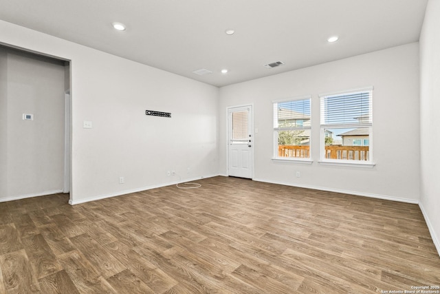 spare room with baseboards, visible vents, wood finished floors, and recessed lighting