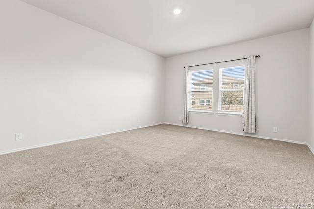 carpeted spare room featuring baseboards