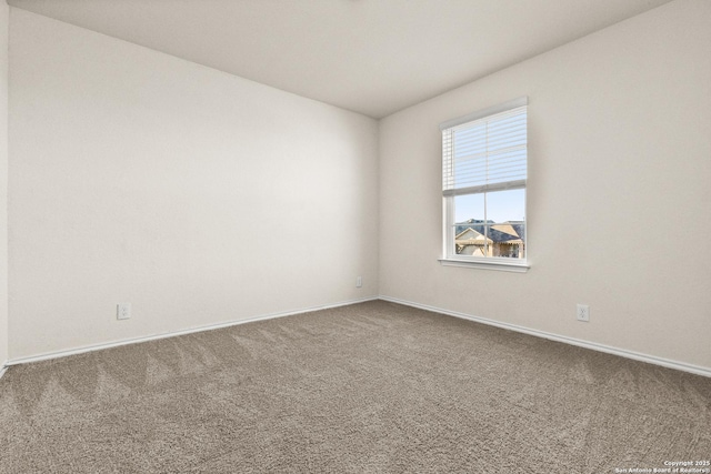 empty room featuring carpet and baseboards