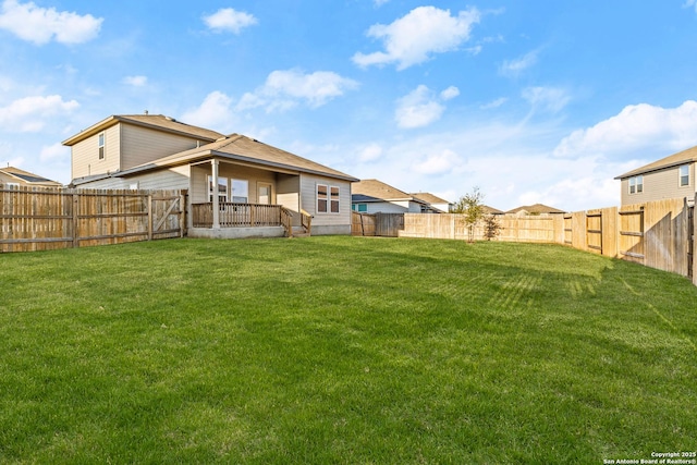 back of house with a fenced backyard and a lawn