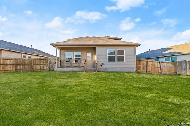 rear view of property featuring a fenced backyard and a lawn