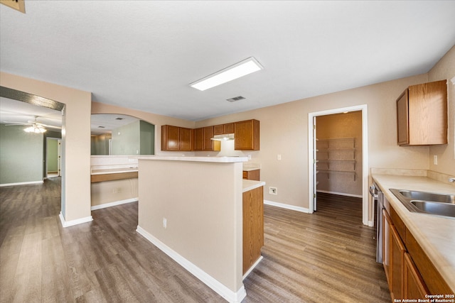 kitchen featuring dark wood-style flooring, a sink, visible vents, light countertops, and brown cabinetry