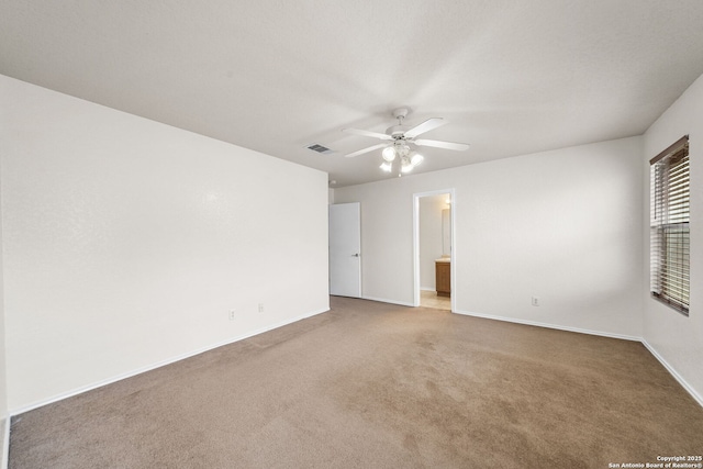 carpeted empty room with a ceiling fan, visible vents, and baseboards