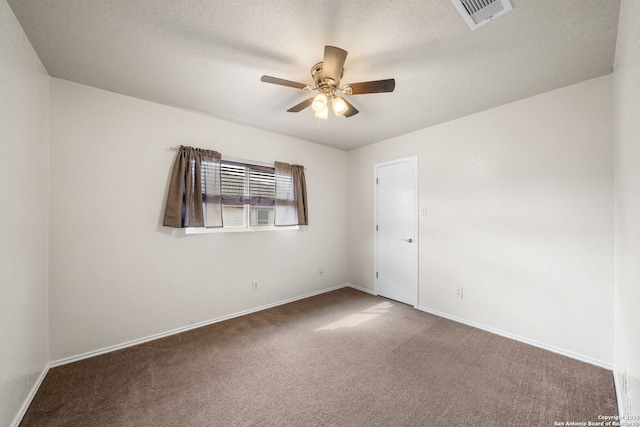 unfurnished room with a textured ceiling, carpet flooring, visible vents, baseboards, and a ceiling fan