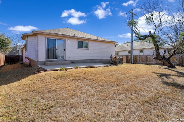 rear view of property featuring entry steps, a patio area, a fenced backyard, and a yard