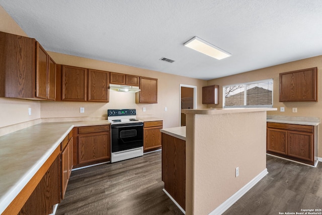 kitchen with brown cabinetry, range with electric stovetop, visible vents, and under cabinet range hood