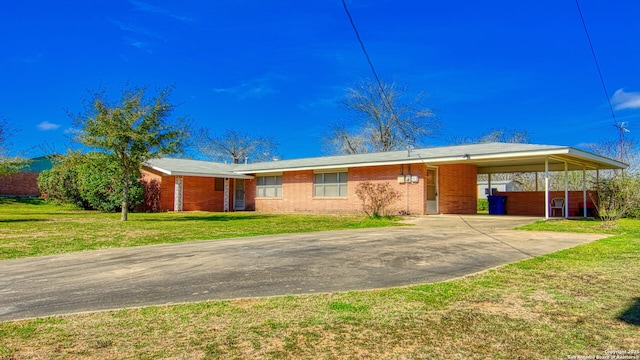 ranch-style home with an attached carport, concrete driveway, brick siding, and a front yard