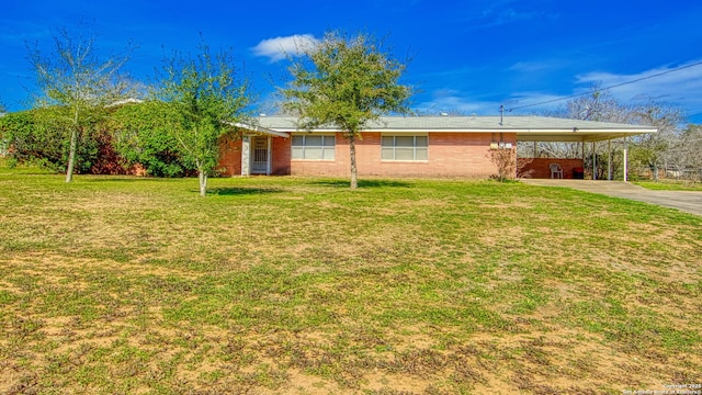 view of front of property featuring driveway, brick siding, a front yard, and an attached carport