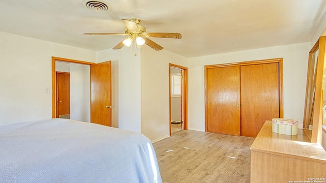 bedroom featuring light wood-style flooring, visible vents, ceiling fan, and a closet