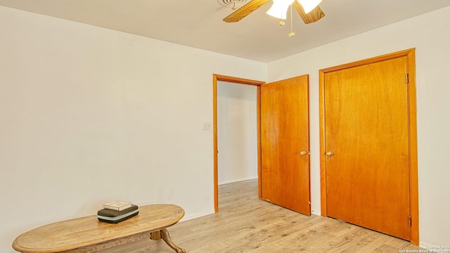 unfurnished bedroom with ceiling fan, light wood-style flooring, and baseboards