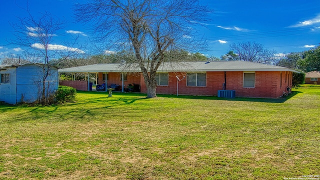 rear view of property with cooling unit, brick siding, and a lawn