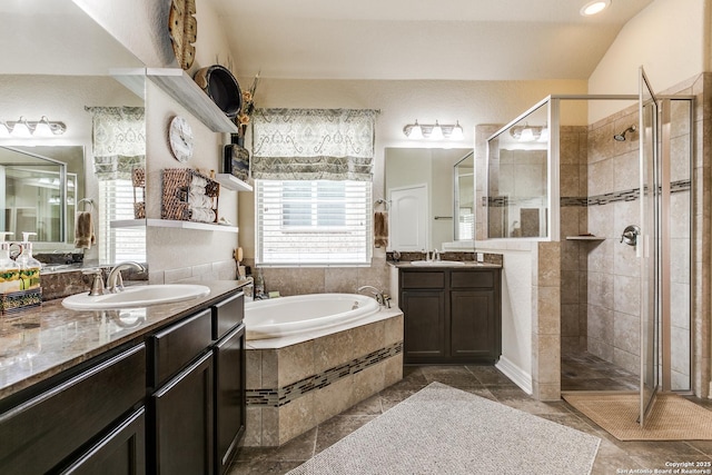 bathroom with a garden tub, two vanities, a sink, and a shower stall