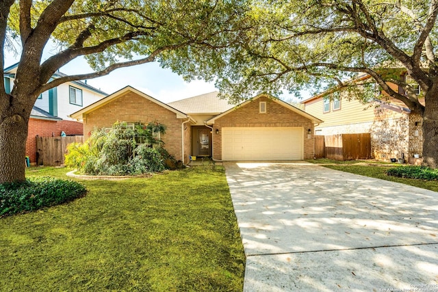 view of front of house featuring brick siding, an attached garage, a front yard, fence, and driveway