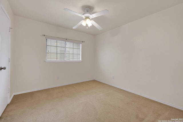 empty room with light carpet, a ceiling fan, and baseboards