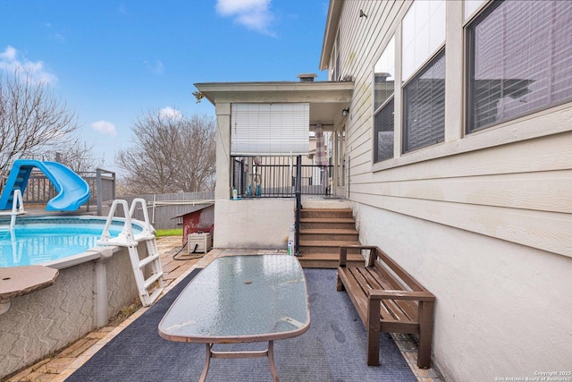 view of patio with outdoor dining area, fence, and a fenced in pool