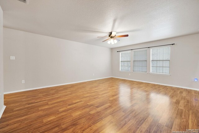 unfurnished room featuring light wood-style floors, baseboards, and a ceiling fan