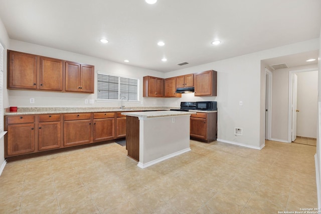 kitchen with brown cabinets, a sink, visible vents, and black appliances