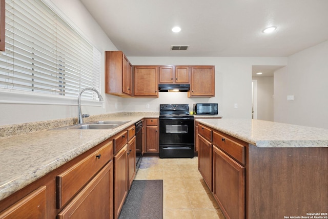 kitchen featuring light countertops, visible vents, a sink, under cabinet range hood, and black appliances