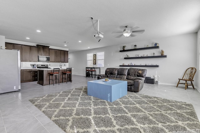 living room with recessed lighting, a ceiling fan, light tile patterned flooring, a textured ceiling, and baseboards