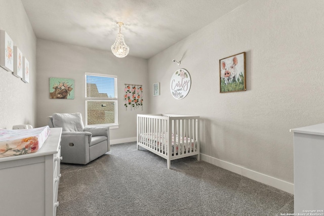 bedroom with carpet floors, a nursery area, baseboards, and a textured wall