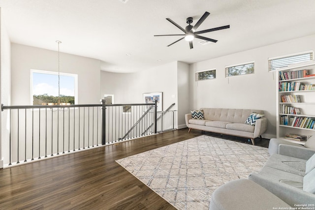 living area featuring wood finished floors and ceiling fan with notable chandelier