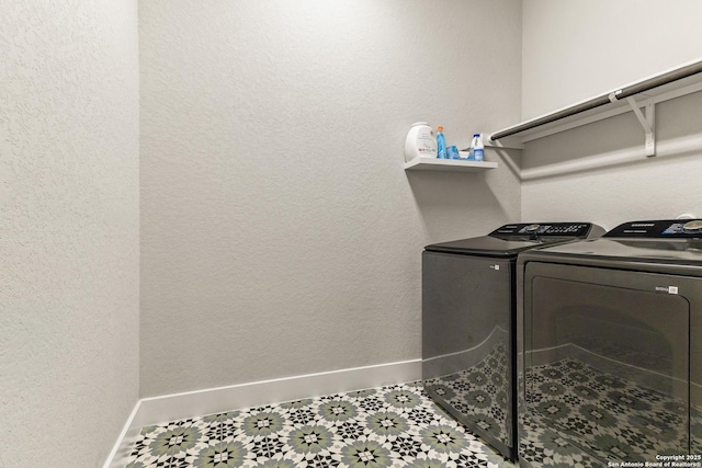 clothes washing area with laundry area, independent washer and dryer, and baseboards