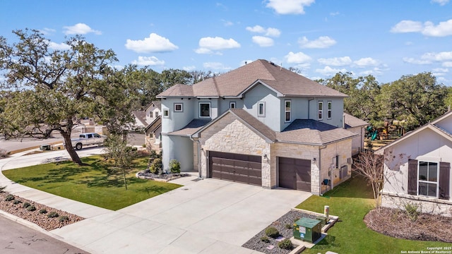 view of front facade with stone siding, a front yard, concrete driveway, and an attached garage