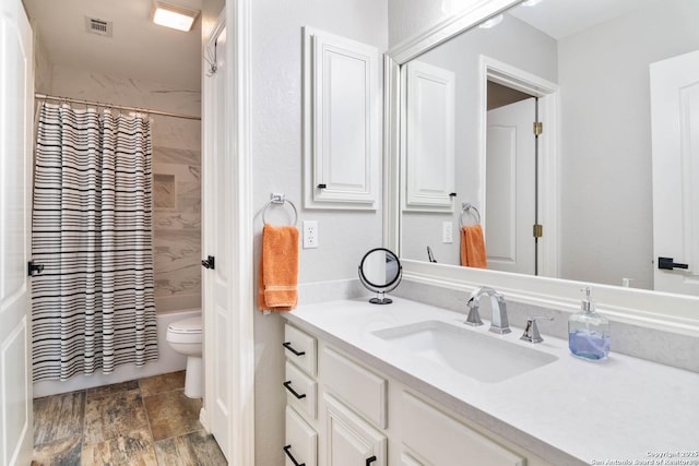 full bath with visible vents, shower / tub combo with curtain, vanity, and toilet