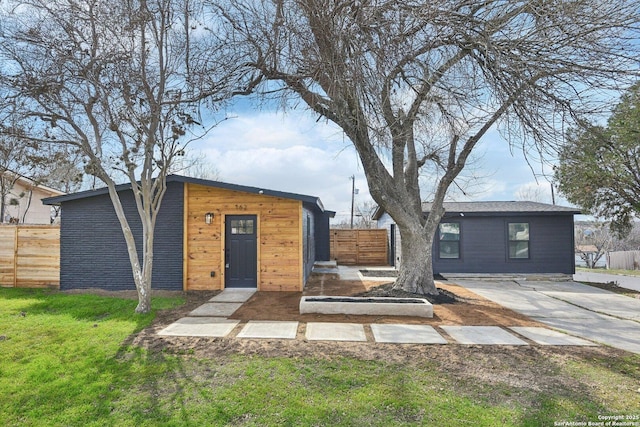 exterior space featuring a front lawn, an outdoor structure, and fence