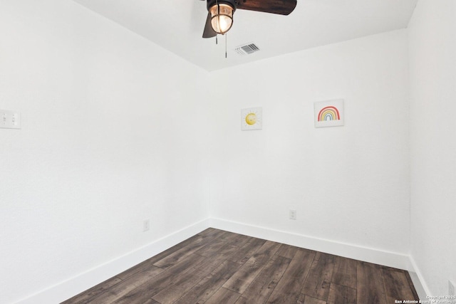 empty room featuring a ceiling fan, baseboards, visible vents, and dark wood-style flooring