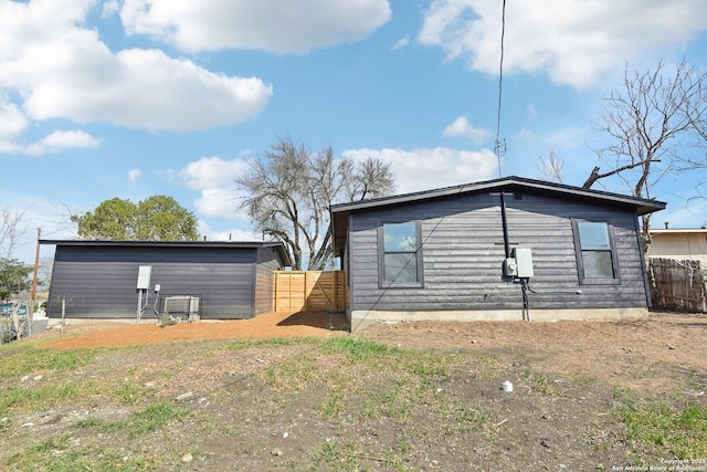 view of side of home with cooling unit and fence