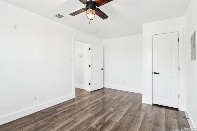 unfurnished bedroom featuring a ceiling fan, visible vents, dark wood finished floors, and baseboards